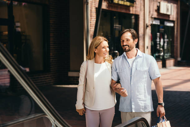 istock happy couple stepping on escalator in shopping mall 1001575954