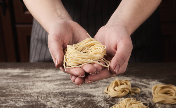istock Woman making tagliatelle nest on kitchen table 1001579218