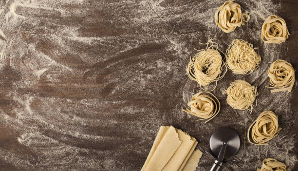 istock Raw tagliatelle nest and dough on kitchen table 1001579560