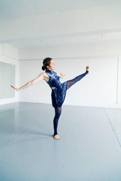 istock Young female performer practicing contemporary dance elements in white spacious loft. Natural lighting. Vertical composition, copy space. 1001580198