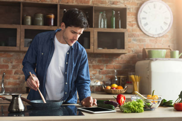 istock Happy man preparing healthy food in kitchen 1001580712
