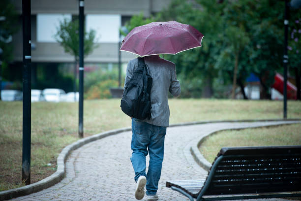 Business Man Walking Under The Rain stock photo