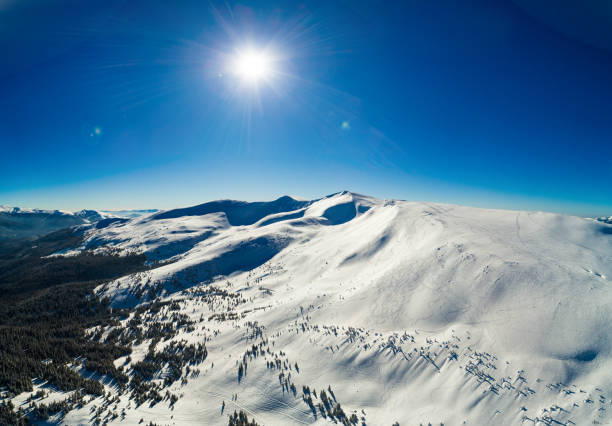 Fly over winter Carpatian mountains top, wide view panorama, drone camera