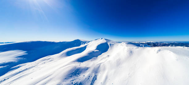 Fly over winter Carpatian mountains top, wide view panorama, drone camera