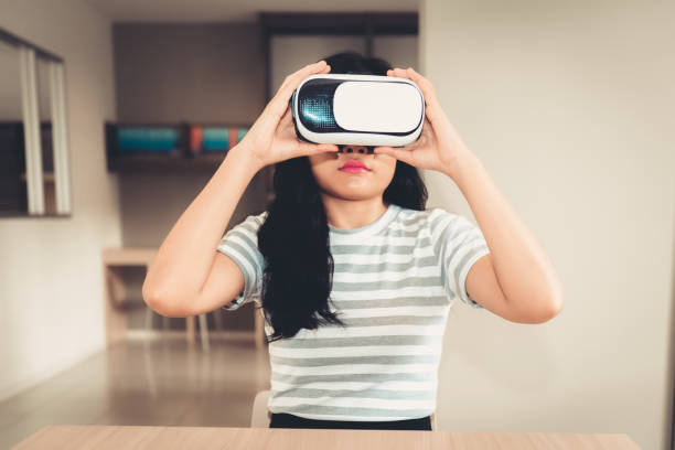 istock Young woman is wearing virtual reality glasses in library room 1001587968