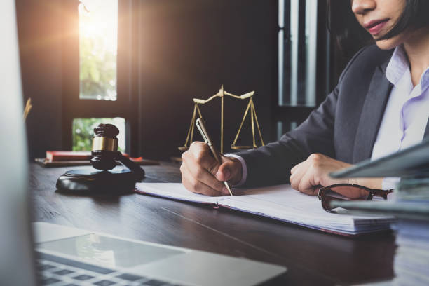 istock advice and justice concept. Justice scales, justice hammer and Litigation and Litigation document, female lawyer using pen point law book, working legal law with use laptop at  lawyer office. 1001595712