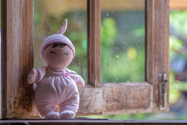 Doll girl  by the window alone .