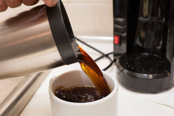 istock image of a hand pouring some long coffee into a white cup 1001603778