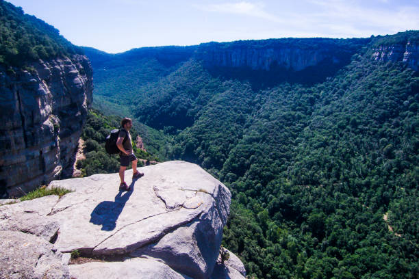 istock Risky mountaineer on a cliff looking at the horizon. 1001607604