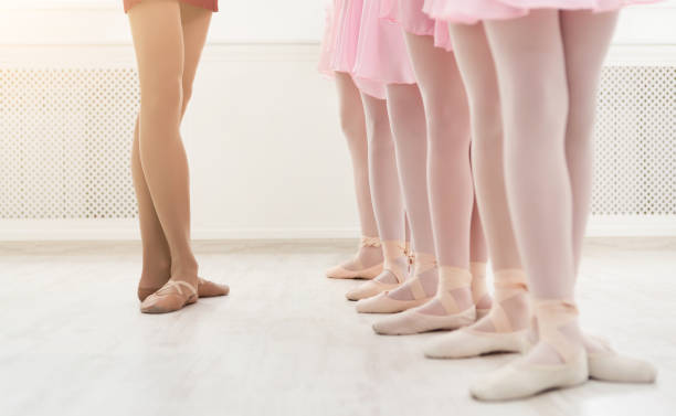 Ballet background, young ballerinas training Ballet background, young ballerinas training. Female dancers legs in pointe shoes, making exercises. Classical dance school, copy space, crop ballet dancer feet stock pictures, royalty-free photos & images
