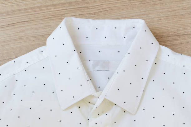 istock white shirt with black dots on wooden background, focus on blank label background and texture 1001608348