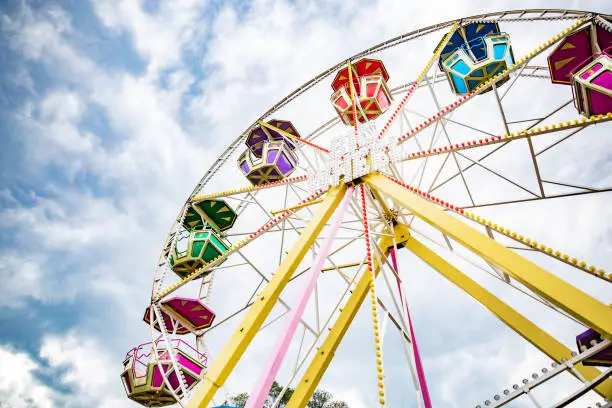 Multicolour ferris wheel on blue sky background. Copy space