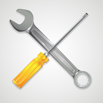 Screwdriver and spanner cross with each other isolated on a white background