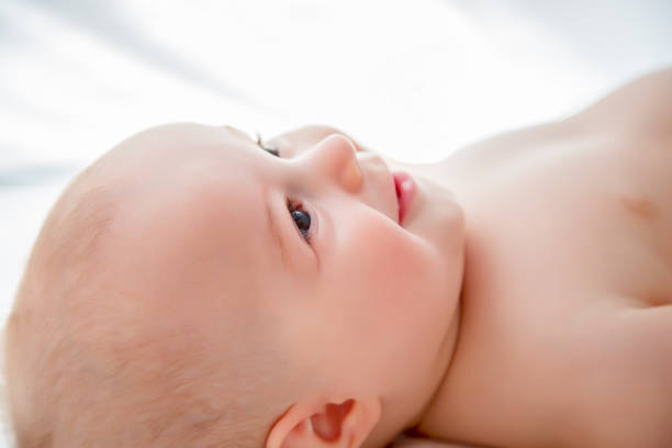 istock Smiling baby boy in white sunny bedroom 1001611074