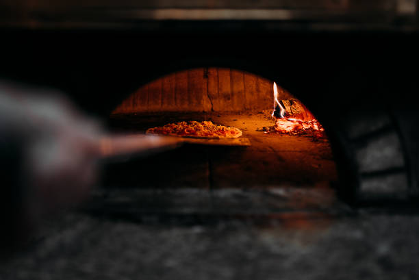 istock Pizza baking in a wood-fired oven. 1001611820