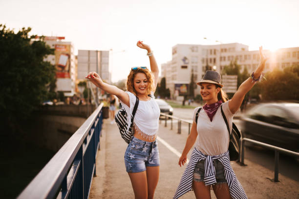 istock Two beautiful young woman dancing on the bridge. 1001611886