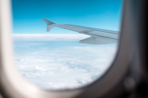 istock Clouds and sky as seen through window of an airplane. 1001612102