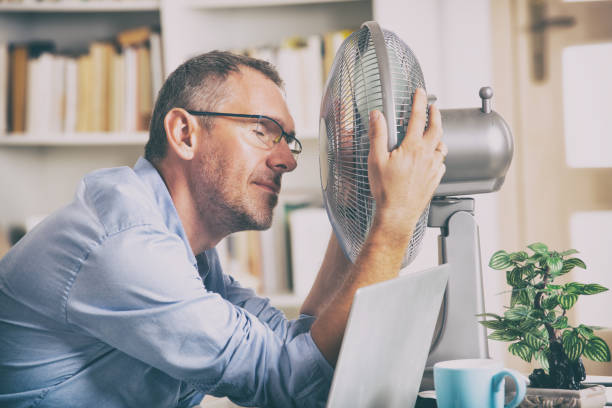 homem sofre de calor no escritório ou em casa - office fan - fotografias e filmes do acervo