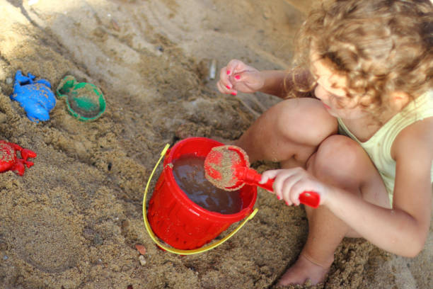 istock Cute little girl play with sand on beach 1001615014