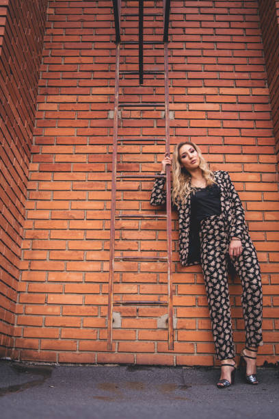 istock Elegant woman posing in front of brick wall 1001618228