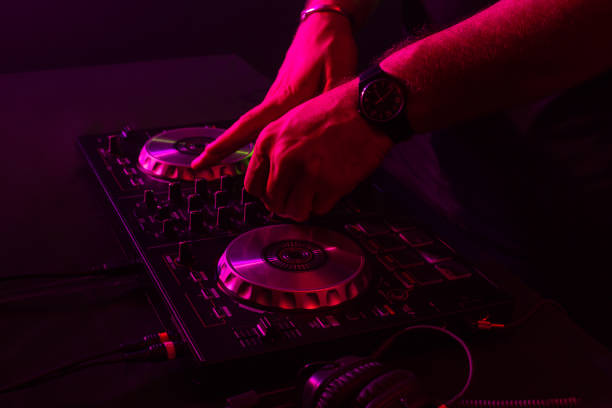istock Dj mixing on turntables with color light effects. Soft focus on hand. Close-up 1001621790