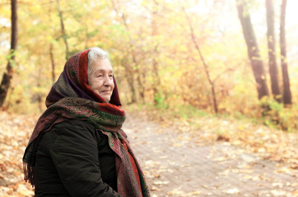 istock elderly woman on a walk in autumn park 1001625274