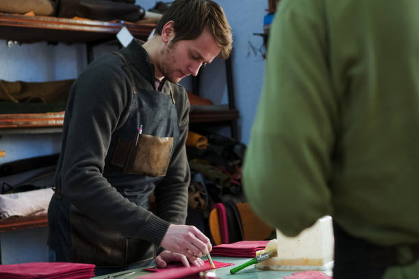 istock Craftsmen prepares leather product for binding 1001625488