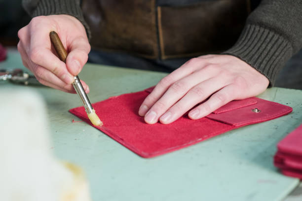 istock Craftsman prepares leather product for binding 1001625492
