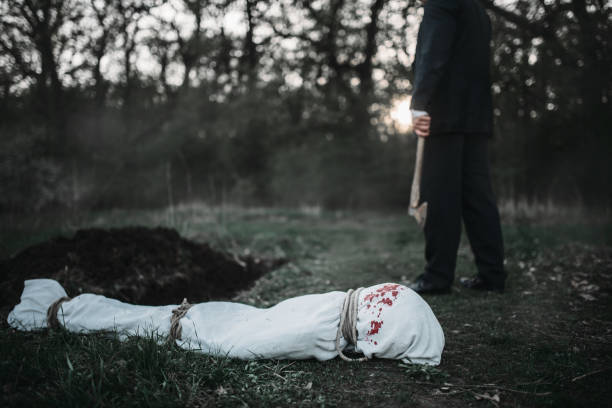 istock Maniac with an axe, victim wrapped in a canvas 1001625560