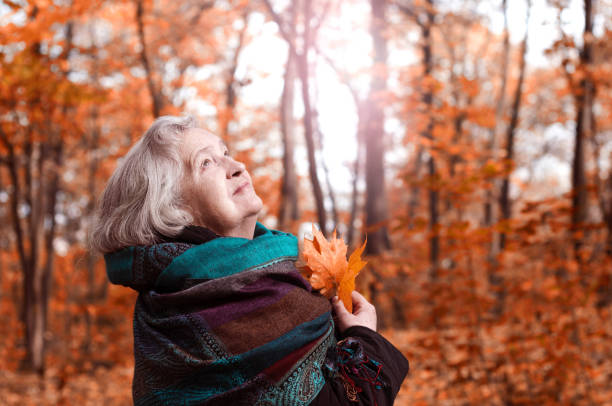 istock elderly woman on a walk in autumn park 1001625566
