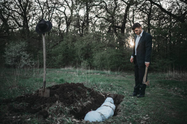 istock Maniac against grave with victim, crime horror 1001625696