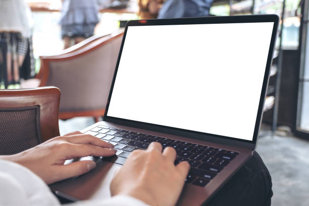 istock Mockup image of a woman using and typing on laptop with blank white desktop screen while sitting in cafe 1001632152