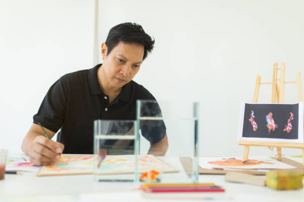 istock Artist painting artwork at workspace , fish inspiration 1001643028