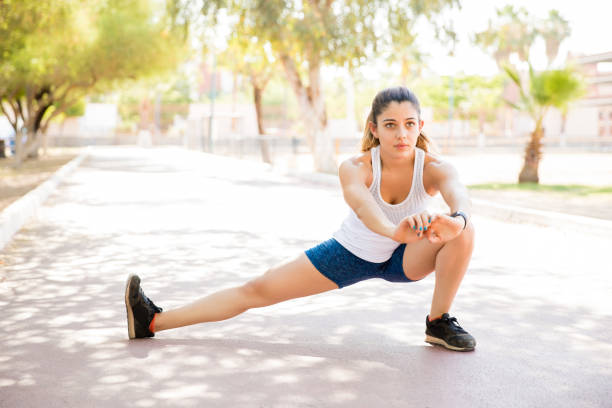 fit young woman exercising in park - leg split imagens e fotografias de stock