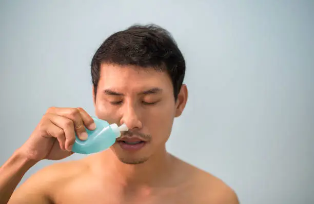 asian man clean sinus on white background