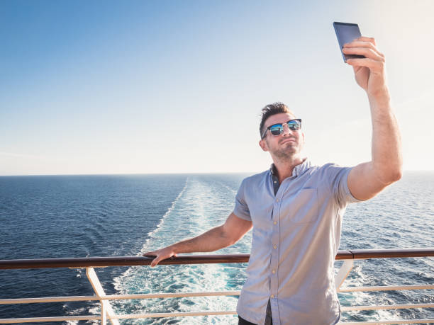istock Smiling man photographing himself on the open deck 1001660824