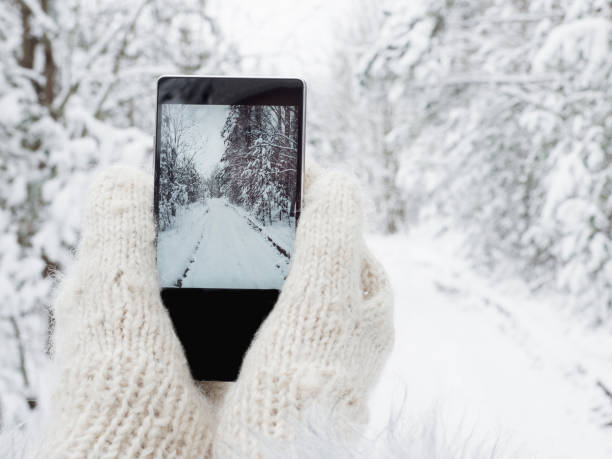 istock Girl is holding a mobile phone in woolen mittens 1001665122