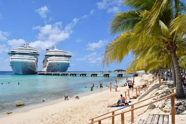 Grand Turk, Turks and Caicos Islands - April 03 2014: Carnival Liberty and Carnival Victory Cruise Ships side by side in Grand Turk while passengers spend a sunny day at Cruise Center (SunRay) Beach on the island.