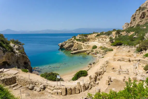 Photo of Panorama of the L- shaped stoa and a beautiful small beach beneath at archaeological site of Heraion, sanctuary of goddess Hera, in Perachora, Loutraki, Greece