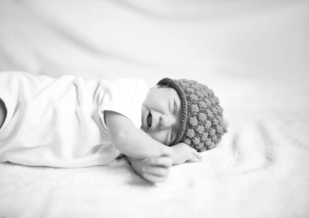 istock newborn baby in knitted hat lying on the white sheet 1001668416