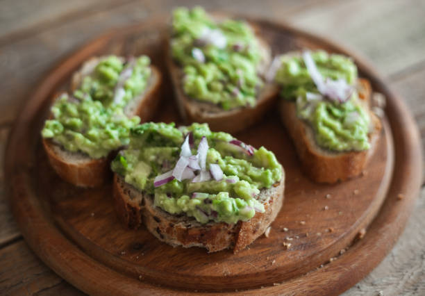istock Avocado guacamole at fresh bread slices, close up, shot from above 1001672108