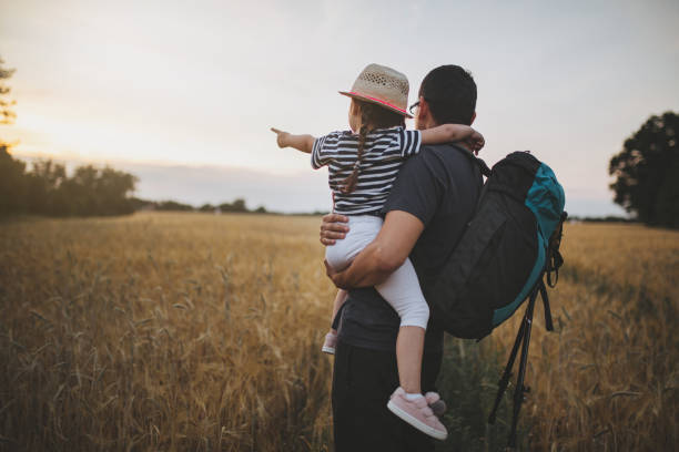 istock Child and her father on a golden meadow 1001672380