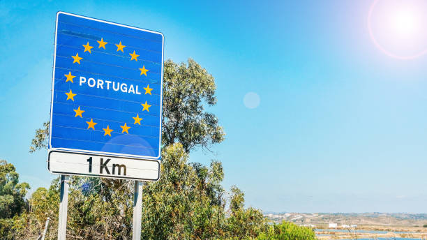 Road sign on the border of Portugal Road sign on the border of a European Union country, Portugal 1km ahead with blue sky copy space. Crossing over on highway from Spain. schengen agreement photos stock pictures, royalty-free photos & images