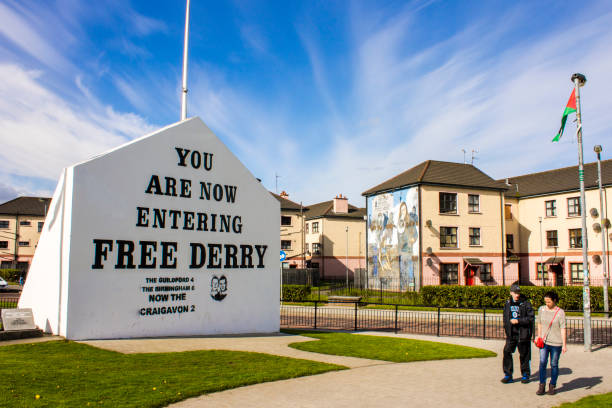 Derry, Northern Ireland The 'You are Now Entering Free Derry' Corner in Londonderry, Northern Ireland, with two passersby soldier on the wall stock pictures, royalty-free photos & images