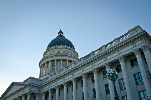 A ground side view of the grand utah state capitol in the evening summer sun.