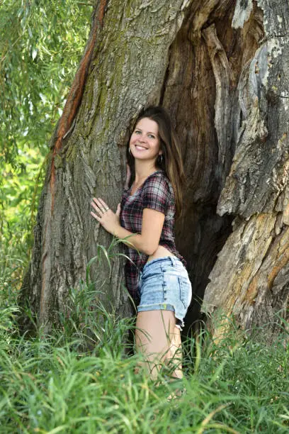 Photo of Young Canadian Woman Inside a Large Tree Trunk