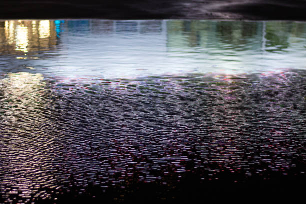 Reflection of colorful city lights in a puddle at night