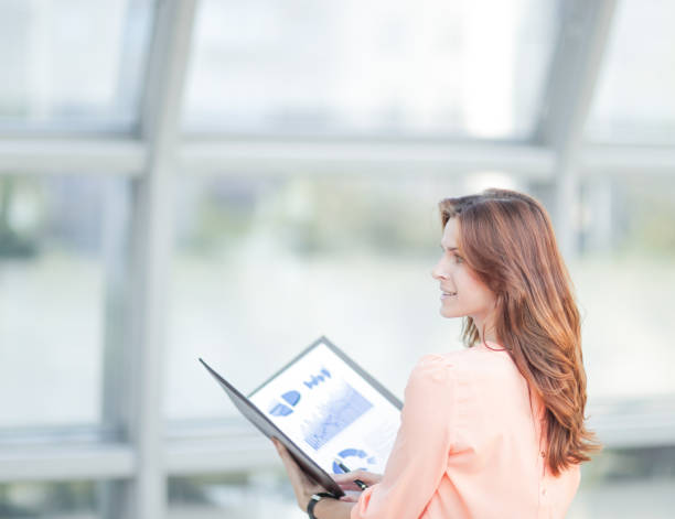 istock rear view.a young business woman holds a folder with financial documents 1001688128