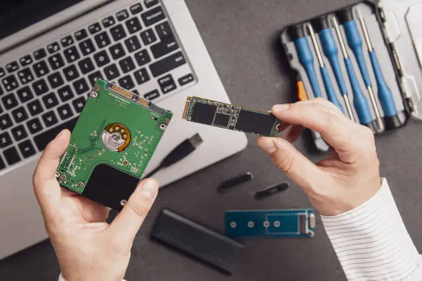 Man prepares to replace an old HDD drive with a modern M.2 SSD in his laptop