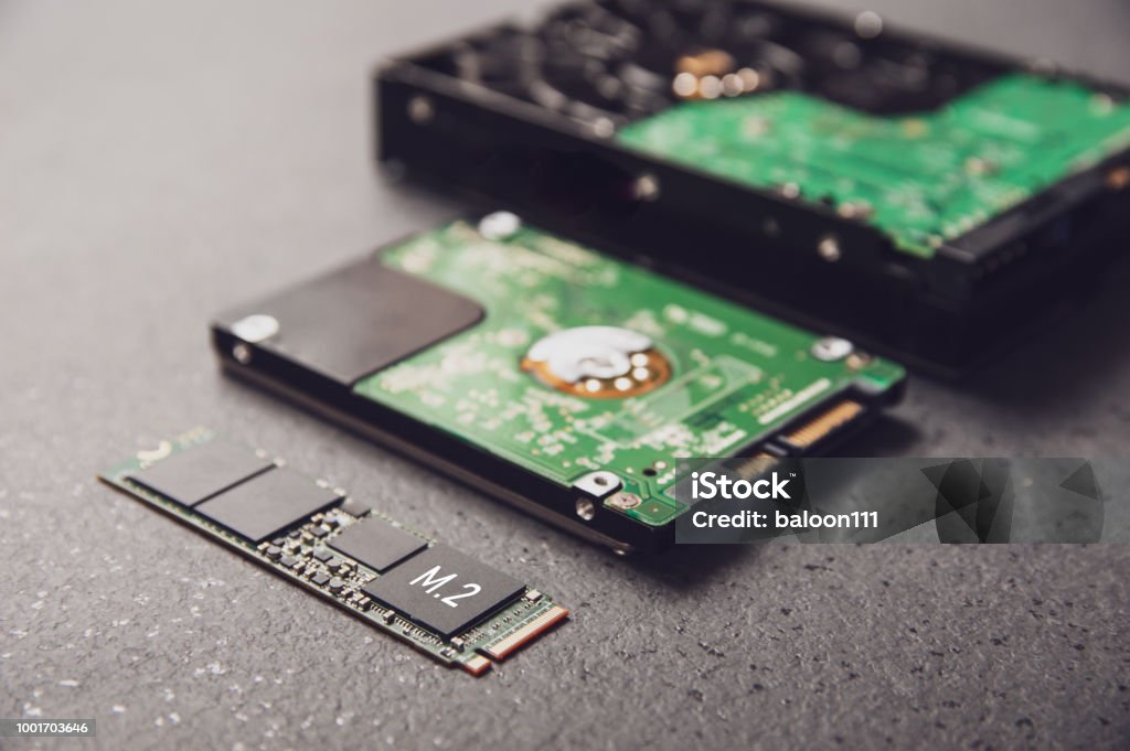Drives arranged on a stone table symbolizing the development of technology from HDD to SSD Disk Stock Photo
